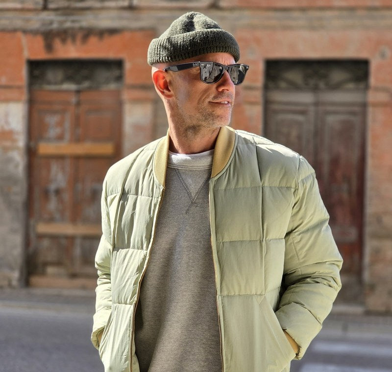 Man in the street wearing a sage Chesapeake's down jacket and a beanie; next to him, a man in a Chesapeake's peacoat with an orange beanie.